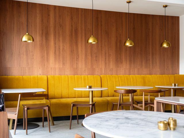 Custom mustard banquette seating in a modern Malaysian cafe interior